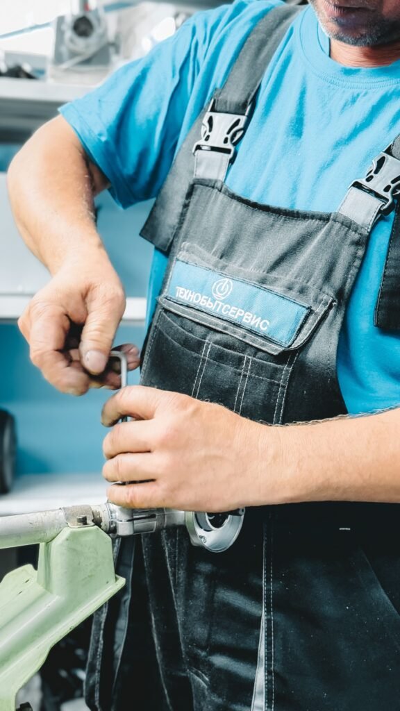 Technicien qui serre un raccord pendant le branchement lave-vaisselle