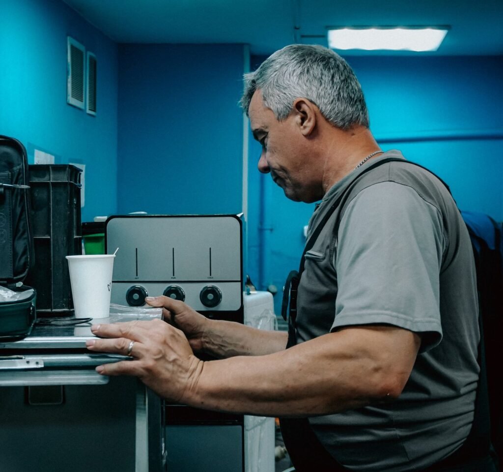 Technicien en réparation d’électroménagers d’expérience qui vérifie un appareil de cuisson électrique