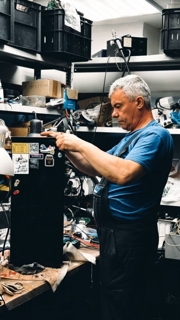 Technicien en réparation cuisinière Sherbrooke qui teste une pièce électrique