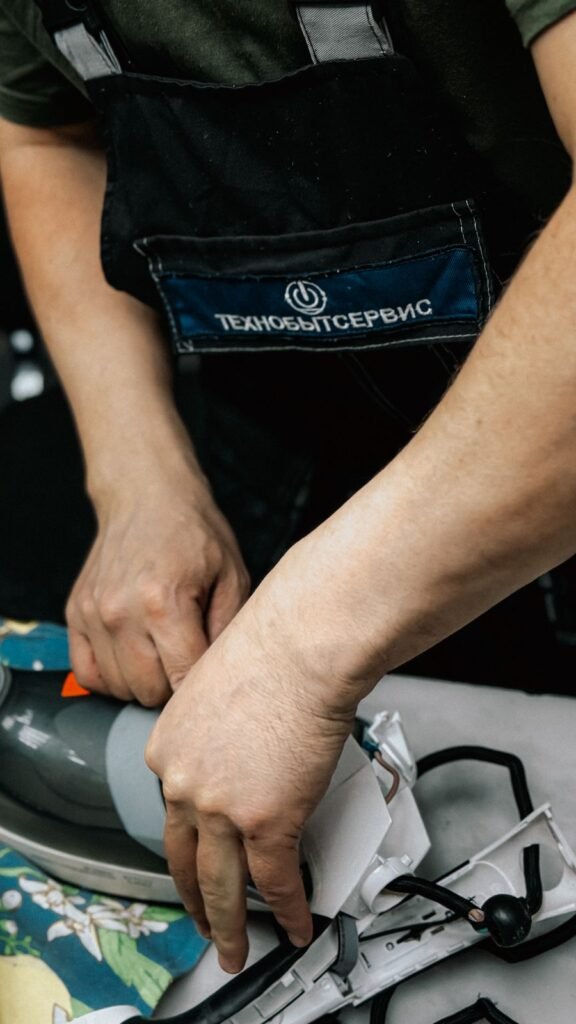 Gros plan d’un technicien qui répare une pièce d’électroménager